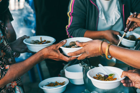 Poor people's hands share free food from volunteers who donate food : concept of feeding, sharing foodの写真素材