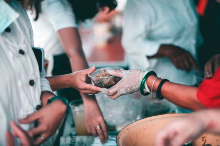 Hungry homeless people request free food donations from volunteers : social concept of helpingの写真素材