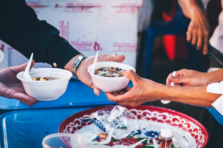 Volunteers serving hot meals to hungry migrants: humanitarian aid concept.の写真素材