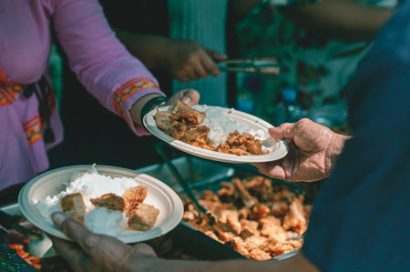 Volunteers are helping to give free food to the hungry homeless : food service and food donation conceptの写真素材