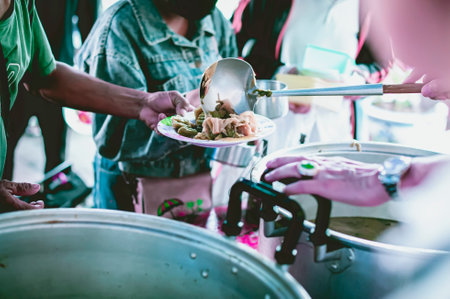 Giving food to beggars to help reduce hunger with concern : Concepts of food donations and aidの写真素材