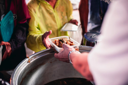 Giving food to beggars to help reduce hunger with concern : Concepts of food donations and aidの写真素材