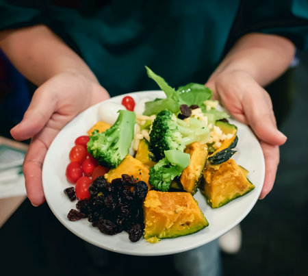 Person holding a plate of healthy food menu with fruits and vegetables.の写真素材
