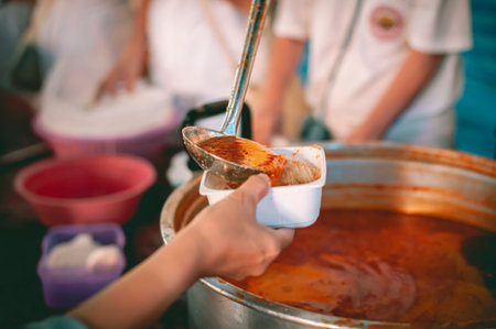 Feeding the poor to hands of a beggar Poverty concept Charity concept, hands of the poor receive food from the donor's shareの写真素材