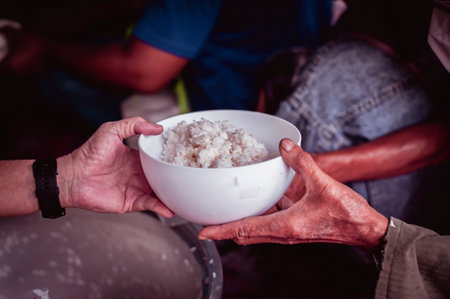 The hands of the hungry get food from the hands of volunteers, Food Donations for Homelessの写真素材