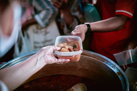 volunteers give food to local poor people, Feeding the poor Help them relieve hungerの写真素材