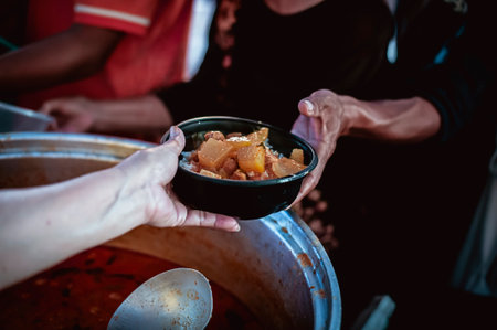 The hands of the hungry are asking for food from the donorの写真素材