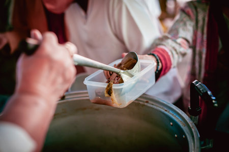 The hands of the hungry get food from the hands of volunteers, Food Donations for Homelessの写真素材