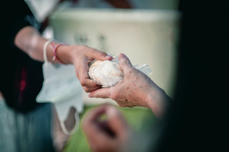 Volunteers are giving food to the homeless poor, Free distribution of food to the poor in today's societyの写真素材