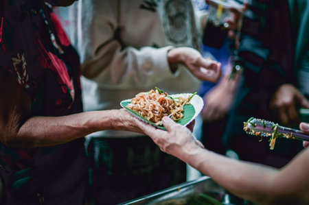 The hands of the hungry are asking for food from the donorの写真素材