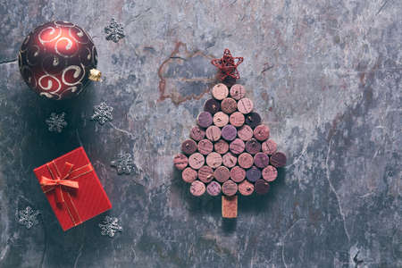 Wine corks shaped Christmas tree on a dark stone background with Christmas decorations.の写真素材