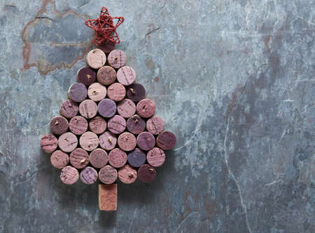 Wine corks shaped Christmas tree on a dark stone background with Christmas decorations.の写真素材