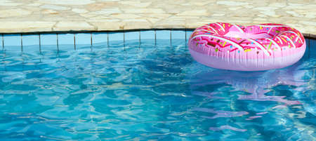 Inflatable in outdoor swimming pool on a hot sunny summer day