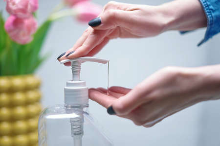Close up image of woman applying sanitizer gel. Cleaning, washing hands with alcohol-based hand sanitizer liquid, using disinfectant.の写真素材