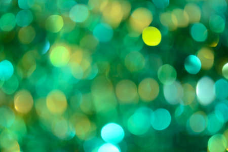 Bokeh. Holiday background. Christmas lights. Glitter. Defocused sparkles. New Year backdrop. Festive wallpaper. Blinks. Carnival. Tinsel. Bokeh retro style photo. Green.の写真素材