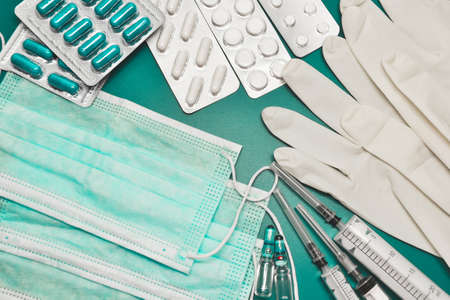 Medical equipment. Coronavirus protection. Medical face mask. Sterile gloves. Syringe and drugs. Doctor uniform for patient treatment in hospital. Prevention the spread of COVID-19.の写真素材