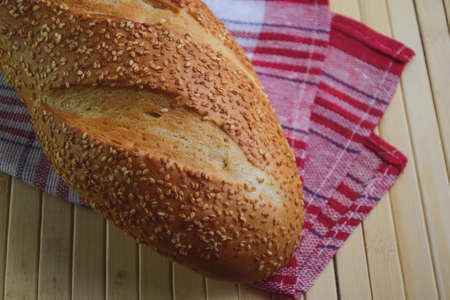 Bread. Wheat flour freshly baked bun with sesame seeds. Retro style background. Country style....