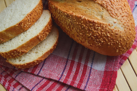 Bread. Wheat flour freshly baked bun with sesame seeds. Retro style background. Country style....