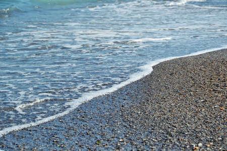 Seashore. Blue sea waves on the beach. Sandy beach. Sea water. Sea shells. Summer background. Waves...