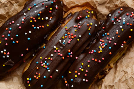 Eclair. Profiterole. Classic French dessert. Choux dough. Pastry filled with cream. Chocolate icing.