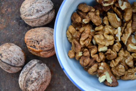 Walnuts harvest on vintage metal background. Walnut kernels from village garden. Organic autumn nuts...