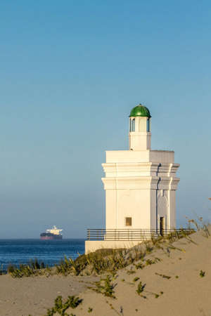 Symbolic lighthouse with boat in backgroundの素材