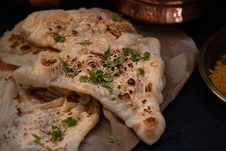 Indian naan and herbs on dark backround