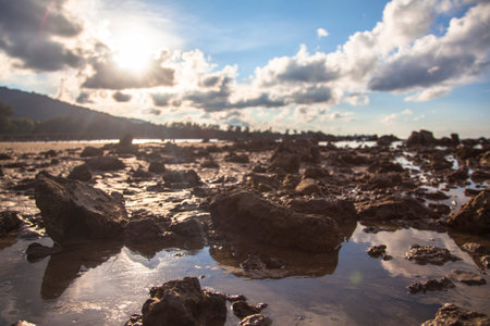 Mud and pebbles on the beach with sun and blue sky, Bangka Belitung, Indonesiaの写真素材