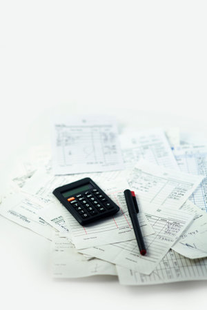 Calculating numbers for bill with pen and calculatorの写真素材
