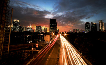 Light trails on the busy street at sunset in Jakarta, Indonesiaの写真素材