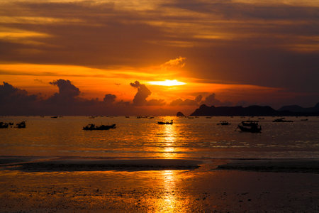 Silhouette fishing boat at sunset in Selong Belanak Beach, Lombok, Indonesiaの写真素材