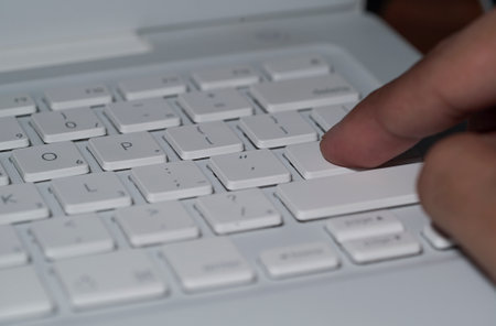 Close up on fingers texting on a computer keyboard