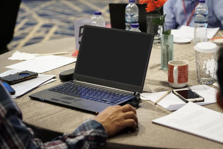 Businessman using the laptop with blank screen in meeting roomの写真素材