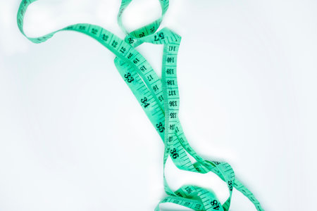 New green measuring tape isolated on whiteの写真素材