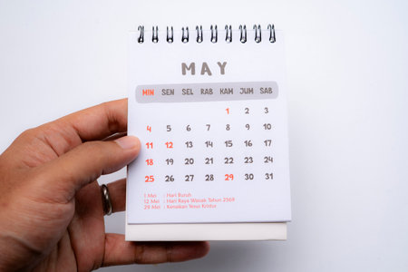 hand holding desk calendar showing may month