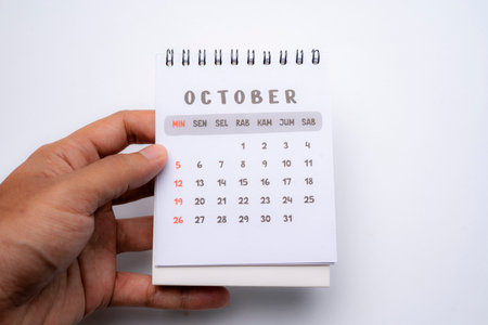 hand holding desk calendar showing october monthの写真素材
