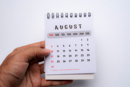 hand holding desk calendar showing august monthの写真素材
