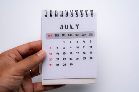 hand holding desk calendar showing july monthの写真素材