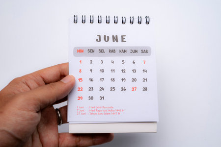 hand holding desk calendar showing june month