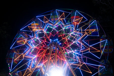 A Ferris wheel ride, commonly found in Indonesia, spinning at a traditional night market in Indonesiaの写真素材