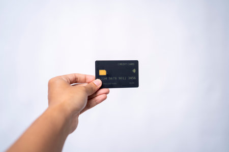 Hand holding a black credit cardの写真素材