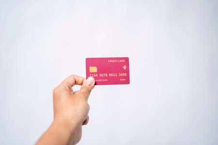 Hand holding a pink credit cardの写真素材