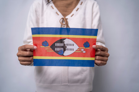 A person holding the flag of Eswatini with pride, symbolizing patriotism, unity, and national identity. The image reflects love for the homeland and respect for Eswatiniâs rich cultural heritage and traditionsの写真素材