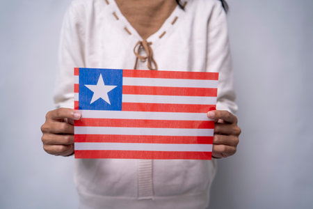A person holding the flag of Liberia with pride, symbolizing national unity, freedom, and resilience. The image reflects patriotism and love for the West African nationâs rich history and independence.の写真素材
