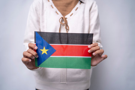 A person holding the flag of South Sudan with pride, symbolizing patriotism, unity, and national identity. The image reflects love for the homeland and respect for South Sudanese culture and independenceの写真素材