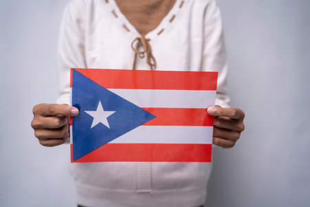 A person holding the flag of Puerto Rico with pride, symbolizing patriotism, unity, and cultural identity. The image reflects love for the island, national pride, and the vibrant Puerto Rican spirit.の写真素材