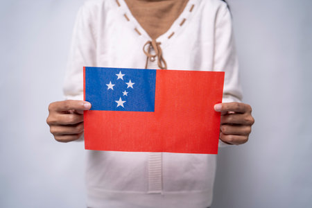 A person holding the flag of Samoa, symbolizing patriotism, unity, and cultural pride. The image reflects love for the homeland and respect for Samoan heritage and traditionsの写真素材