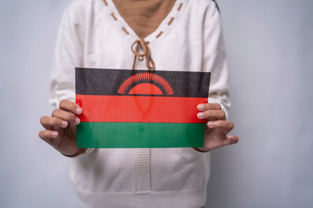 A person holding the flag of Malawi with pride, symbolizing national unity, hope, and identity. The image reflects patriotism and love for the African nation known as the âWarm Heart of Africaの写真素材