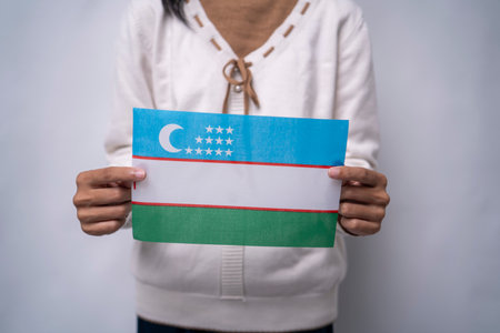 A person holding the flag of Uzbekistan with prideの写真素材