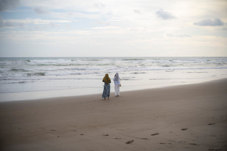 Two Women Walking Along Quiet Sandy Beach